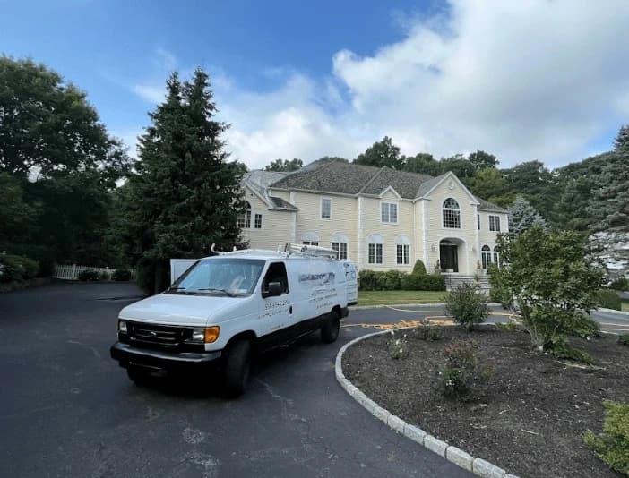 Hudson Power Washing technician performing thorough gutter cleaning service in Hudson