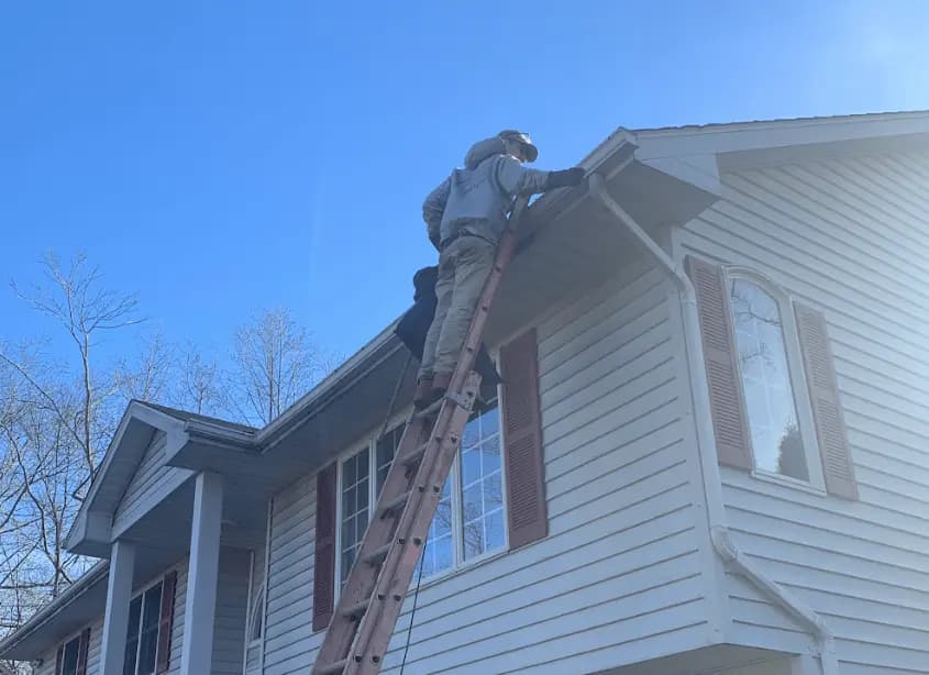 Gutter cleaning and maintenance being performed by Hudson Power Washing in Hudson